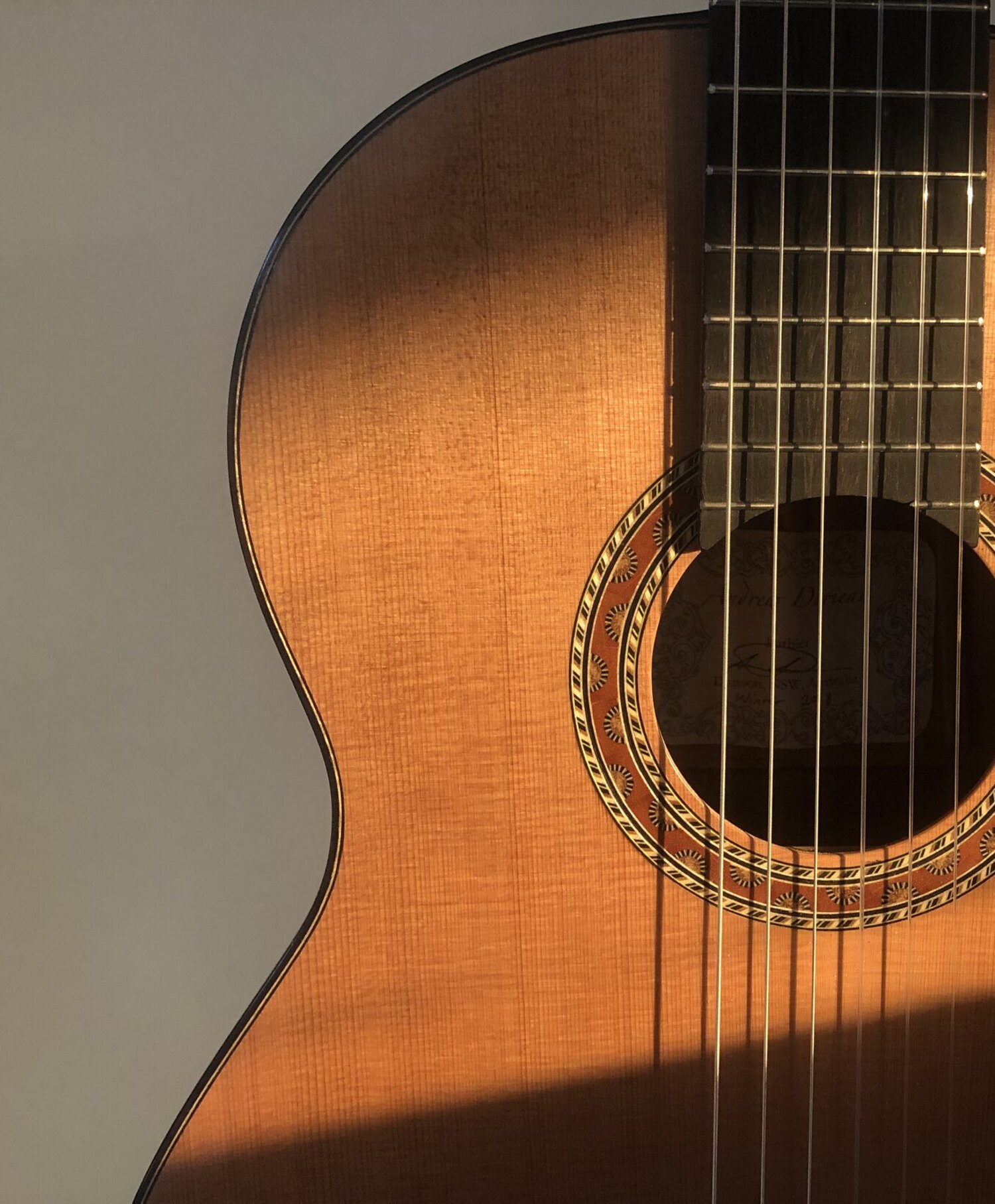 Sunlight across the rosette and soundhole of a Doriean classical guitar
